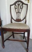 A set of eight mahogany shield-back dining chairs with carved and pierced splats, tapering