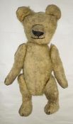 An early 20th century teddy bear, having swivel head, elongated moveable arms and legs, 29 cm high