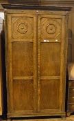 Twentieth century oak wardrobe, with blind fret carved frieze, single shelf and hanging rail to