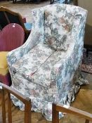 Old wing armchair with floral print loose cover, cushion seat, on bun feet with castors