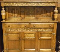 Reproduction oak court cupboard, the top with scroll carved frieze on foliate cup and cover carved