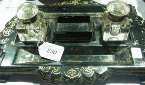 A papier mache inkstand with two inkwells, gilt decorations, a little damaged