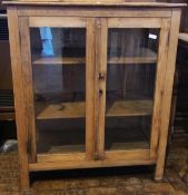 An old pine glazed cupboard the pair panelled doors enclosing shelves, glazed panels to front and