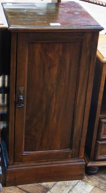 Late Victorian stained walnut pot cupboard, the panelled door enclosing shelf raised on a plinth