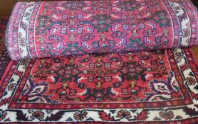 An Iranian wool runner, floral pattern within a red field and multiple borders, 295 x 86 cm