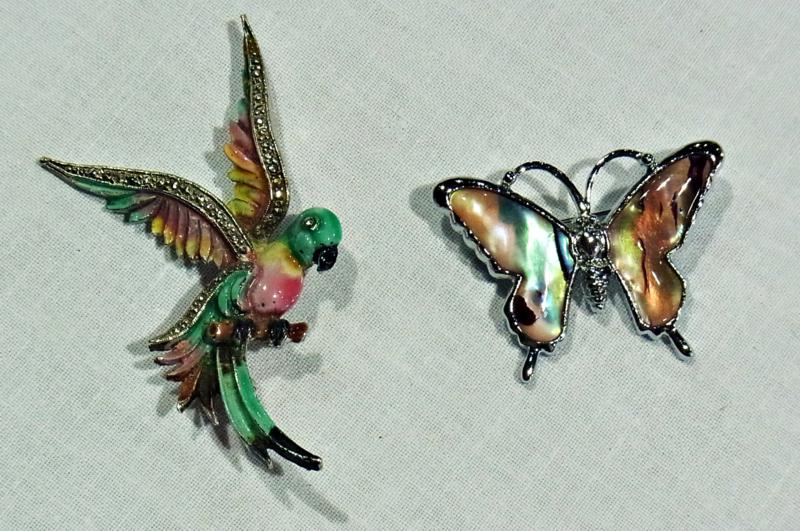 Enamel and silver-coloured brooch in the shape of a parrot and an enamel brooch in the shape of a