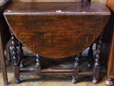 A twentieth century oak oval top gateleg table on turned spiral supports united by stretchers, width