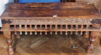 An Indian hardwood rectangular top coffee table, with carved foliate apron frieze, on turned legs,