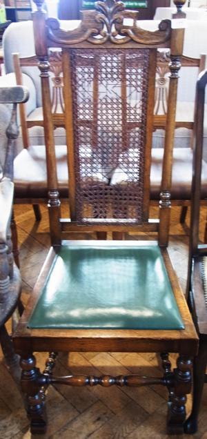 Seventeenth century style high back oak dining chair, with carved crest rail, cane and panel back,