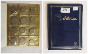 Accumulation of coins of the world in album, including Southern Arabia
