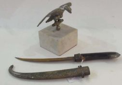 Metal eagle car mascot, on white marble base, the eagle with wings outstretched perched on branch,