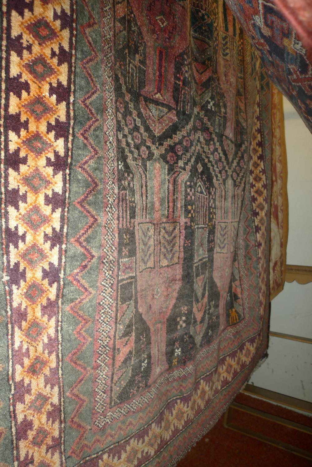 A fine North East Persian Zabul Belouch rug with motifs on a madder ground within repeating stylized