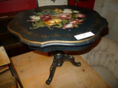 An ebonised and gilt circular low table with painted foliate decoration on pillar and tripod W 70 x