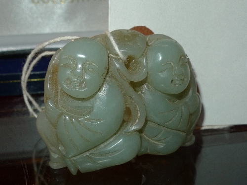 A Chinese green carving of two figures with Lotus leaf ornament W x 6 cm