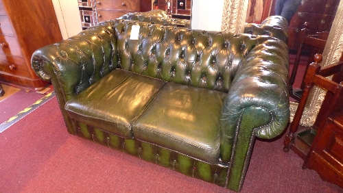 A Chesterfield design two seater settee the buttoned upholstery in green leather W 155 cm