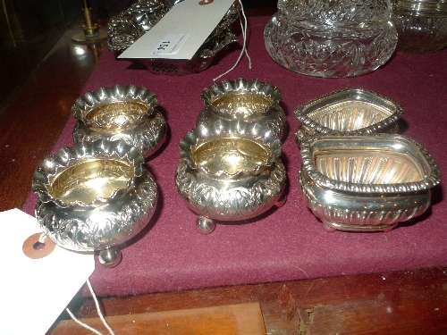 A set of four hallmarked silver salts having repoussage decoration together with a pair of silver