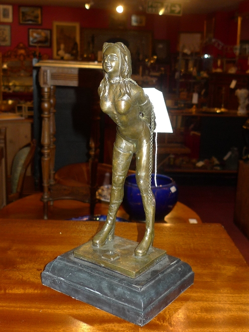 A bronze figure scantily clad female in chains and a similar bronzed figure holding a whip ( 2) H
