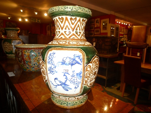 A pair of multicoloured vases the green glaze with bird decorated reserves H x 36 cm