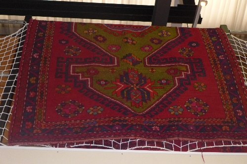 A hand knotted Hamadan the red ground with central medallion and triple border