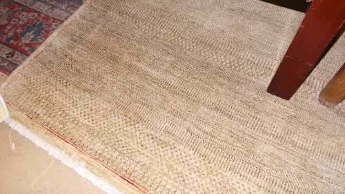 A large stylized beige rug with small tassels to ends W 190 L 290 cm