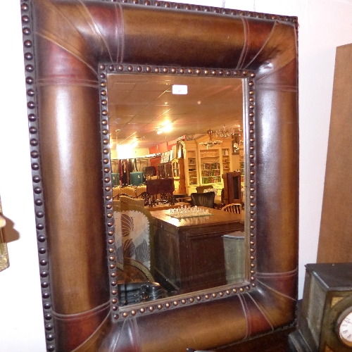 A modern wall mirror the bevelled plate in leather clad frame W 75 X H 95 cm