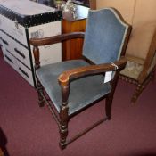 A pair of oak open armchairs with blue upholstery raised on turned supports joined by stretchers