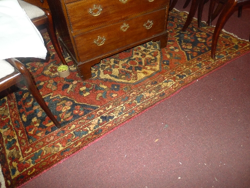 A Bakhtiyar traditional rug with a ring form medallion on a red field with midnight blue spandrels