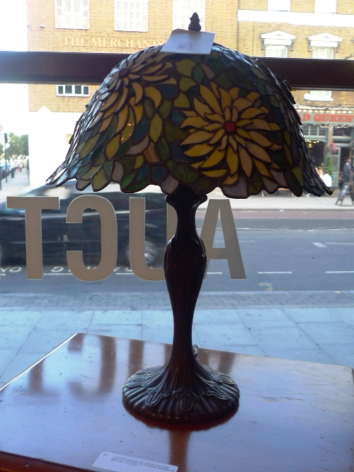 An Art Nouveau design Tiffany style table lamp the sunflower leaded glass shade on a bronzed metal