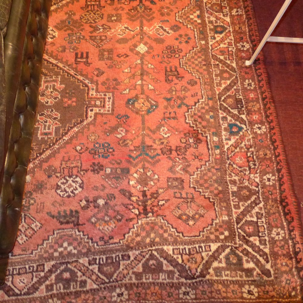 A hand knotted Persian Qashgai carpet the red field with central medallion and geometric design