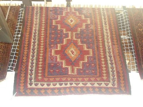 A fine central Persian Kirman runner, triple pole medallions on a rouge field within stylized