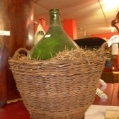 A green glass carboy and basket