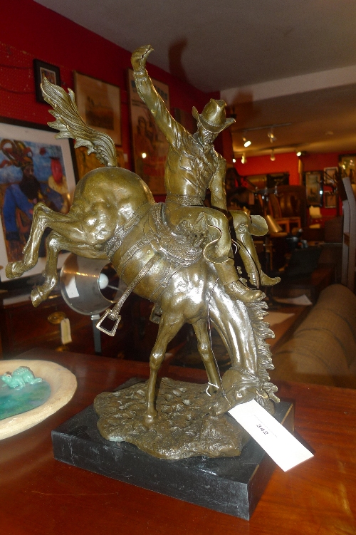 A bronze of a cowboy riding a bucking bronco -Yee-Haaagh - on marble base. 49 cm high.