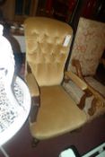 A Victorian mahogany open armchair the buttoned upholstery in yellow velour raised on turned