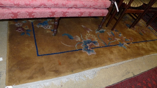 A hand knotted Chinese carpet the gold ground with stylized motifs