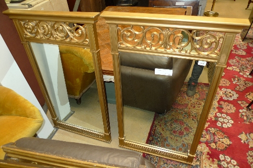 A pair of gilded wall mirrors with scroll carved frieze above rectangular plate W 69cm
