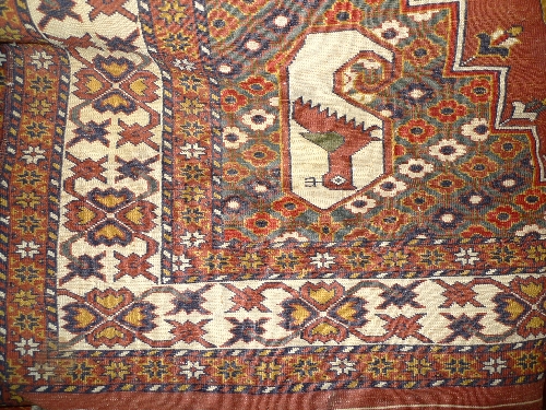 A hand knotted Persian Qashgai carpet the red field with square pattern inset geometric motifs