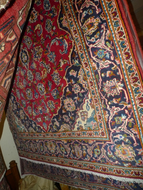 A fine central Persian Kashan carpet with pendent medallion surrounded by flowers on rouge field