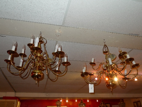 A pair of brass hanging brass chandeliers of scrolling form