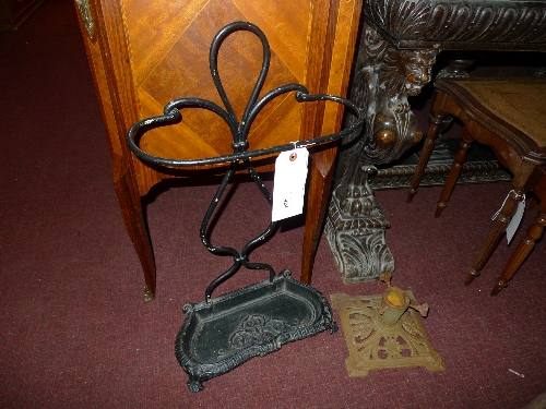 A black painted cast iron umbrella stand together with a cast iron Christmas tree stand