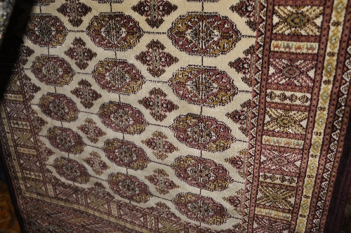 A Persian Bokhara runner the camel field with repeating motifs within a stylized border 280 x 75 cm