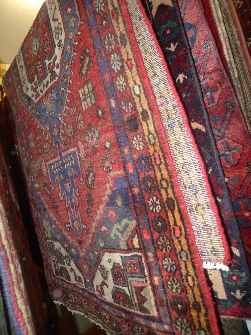 A hand knotted Persian Hamadan rug the red field with central medallion within a triple border