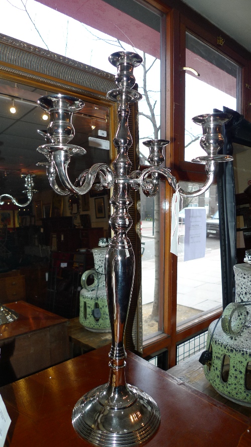 A pair of silver plated five light candelabras of scrolling form