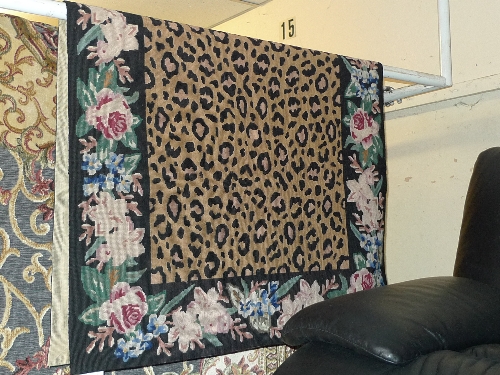 An Aubusson needlepoint wall hanging with leopard print decoration within a foliate border 152cm x