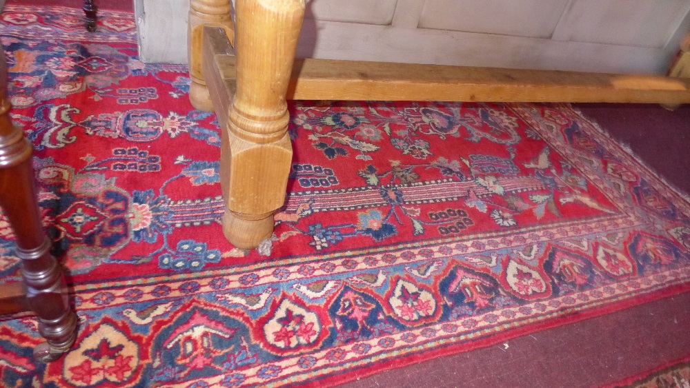 A hand knotted Persian Kashan rug the red field with exotic bird and flowering tree decoration