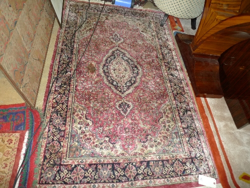 A Chinese part silk rug the pink ground with allover stylized foliate decoration