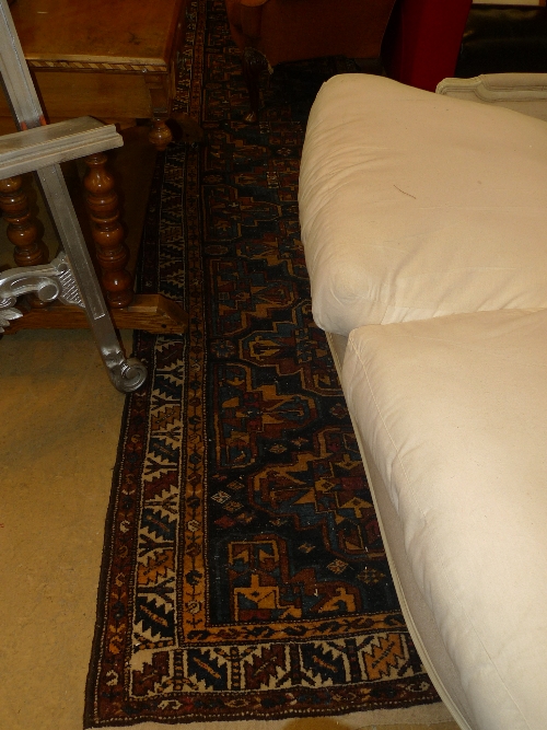A hand knotted Persian runner the blue ground with central medallions