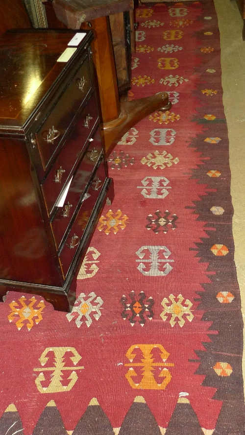 A hand knotted runner the red ground with geometric motifs
