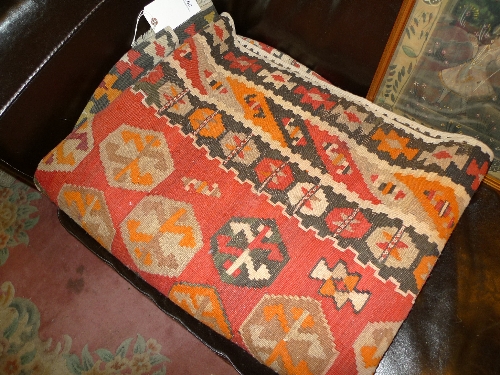 A hand knotted kelim rug the red ground with geometric motifs