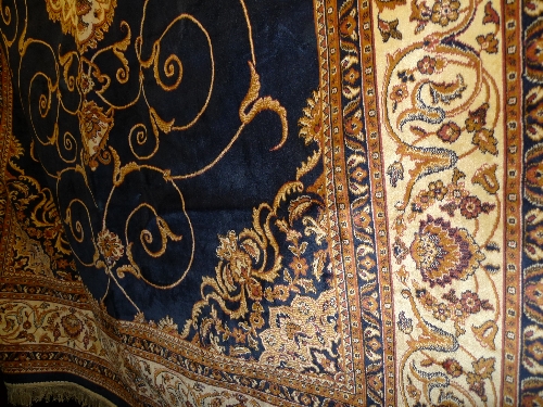 A Kirman design rug the blue field with gold stylized decoration within a foliate border 280cm x