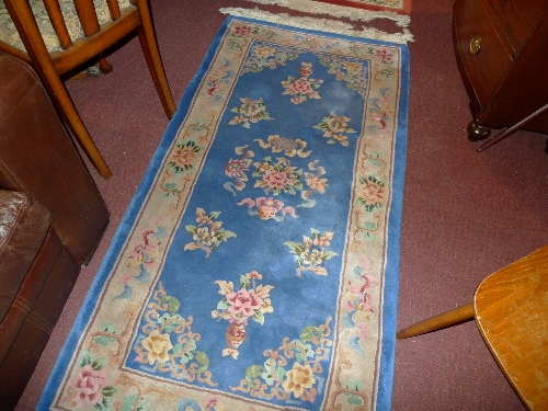 A hand knotted Chinese rug the blue field with foliate decoration and a similar terracotta rug (2)